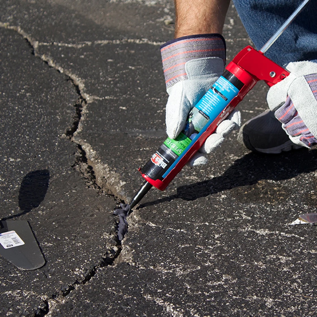 Cracks in asphalt driveway surface before crack filling treatment